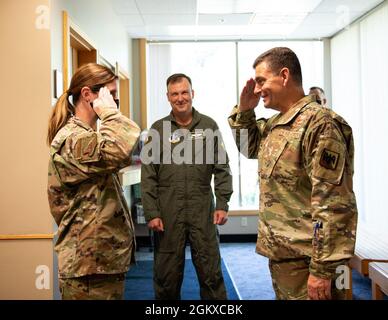 U.S. Air Force Master Sgt. Mandi Johnson, links, 133. Medizinische Gruppe, begrüßt LT. General Michael A. Loh, rechts, Direktor, Air National Guard, nachdem er seine Münze in St. Paul, Minnesota, am 17. Juli 2021 erhalten hatte. Johnson wurde von ihrer Führung als herausragende Leistung für die 133. Medical Group anerkannt. Stockfoto