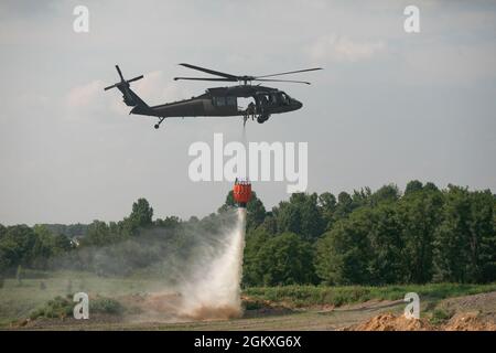 Soldaten der Nationalgarde der Kentucky Army lassen Wasser fallen, während sie am 19. Juli 2021 im Wendhell H. Ford Regional Training Center in Greenville, KY, Wassereimer trainieren. Besatzungsmitglieder von Bravo Co., 2/147. Assault Helicopter Battalion Züge mit UH-60 Black Hawks, um Waldbrände und Waldbrände zu löschen, um lokale Feuerwehren in Kentucky und den Nachbarstaaten zu unterstützen. Dieses Bild wurde elektronisch beschnitten und ethisch verbessert, um das Motiv hervorzuheben, und stellt das Motiv oder das Originalbild in keiner Weise falsch dar Stockfoto