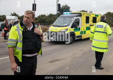 Enfield, Großbritannien. September 2021. Einer von zwei Krankenwagen fährt vorbei, nachdem britische Klimaaktivisten aus einer Zufahrtsstraße von der M25 an der Kreuzung 25 herausgezogen sind, die sie im Rahmen einer Kampagne blockierten, die die britische Regierung dazu drängen sollte, erhebliche Gesetzesänderungen vorzunehmen, um die Emissionen zu senken. Die Aktivisten, die am 13. August an Premierminister Boris Johnson geschrieben haben, fordern, dass die Regierung unverzüglich verspricht, sowohl die vollständige Finanzierung und Isolierung des gesamten sozialen Wohnungsbaus in Großbritannien bis 2025 sicherzustellen als auch innerhalb von vier Monaten einen rechtlich verbindlichen nationalen Plan zur vollständigen Finanzierung zu erstellen Stockfoto