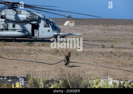 U.S. Marine Corps Lance CPL. Jose Estrada, ein Düsenbediener mit 7th Engineer Support Bataillon, das an Marine Wing Support Squadron 372, 3rd Marine Aircraft Wing (MAW), angeschlossen ist, führt einen Tankschlauch von der Landezone zum Vorwärts-Scharfschaltungs- und Betankungspunkt (FARP), der auf der Insel San Clemente eingerichtet wurde, 20. Juli 2021. Während der Advanced Naval Basing Evolution von Summer Fury 21 richtete die 3. MAW auf dem bestehenden Flugplatz einen FARP ein, um die Reichweite und das Tempo der Flugoperationen im Verantwortungsbereich zu erhöhen, um die Einsatzfähigkeit für die zukünftige conf zu bewerten Stockfoto