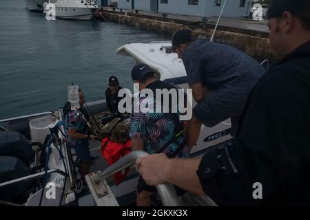 Die Grünen Berets der US-Armee mit dem 2. Bataillon, der 1. Special Forces Group (Airborne), bringen während der Forager 21 in Saipan, Commonwealth der Nördlichen Marianen-Inseln, 20. Juli 2021 einen simulierten Wurfpatienten auf ein Boot zur Evakuierung von Verletzten. Forager 21 ist eine US Army Pacific Stockfoto