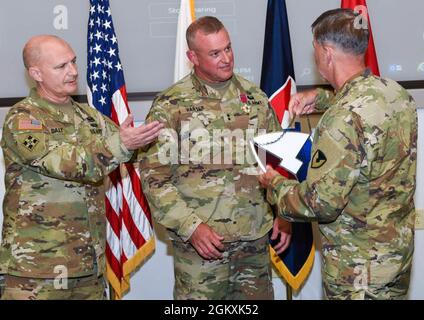 LT. General Donnie Walker, stellvertretender Kommandeur des Army Maternel Command, überreicht dem scheidenden AMC-Stabschef, Major General Bob harter, eine Glasmalerei des AMC-Logos. Das Geschenk gehörte zu mehreren Anerkennungen, die harter während einer Abschieds- und Preisverleihung am 20. Juli im AMC-Hauptquartier, Redstone Arsenal, Alabama, überreicht wurden. Mit ihnen ist AMC-Kommandant General Ed Daly, der bei der Zeremonie amtierte. Harter wird als stellvertretender Chef der Armeereserven, Büro des Chefs der Armeereserven, eingesetzt. Stockfoto