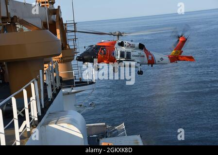 Ein Hubschrauber der Küstenwache MH-60 Jayhawk von der Air Station Kodiak führt Flugoperationen an der Seite des Küstenwache-Schneiders Healy durch. Healy und seine Crew befinden sich derzeit im Rahmen einer Umrundung Nordamerikas auf einem 133-tägigen Einsatz in der Arktis, um Missionen der Küstenwache durchzuführen und wissenschaftliche Forschung zu unterstützen. . Stockfoto