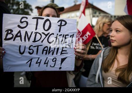 Ein Protestler hält ein Plakat mit der Aufschrift Stop Bandit Act 1449 während der Demonstration.Hunderte von Menschen versammelten sich vor dem parlament in Warschau, um an einem Protest mit dem Titel "Stop Sanitary Segregation" teilzunehmen, der von der rechtsextremen nationalistischen Partei der Konföderation (Konfederacja) organisiert wurde. Die Teilnehmer wollten sich gegen die hygienische Trennung, den Zwang zu COVID-19-Impfungen und das neue Gesetz 1449 wehren - es geht um das Gesetz zur Verhütung und Bekämpfung von Infektionen und Infektionskrankheiten beim Menschen, das unter anderem finanzielle Sanktionen für Menschen vorsieht, die lügen oder während dieser Zeit bestimmte Informationen verbergen Stockfoto