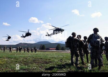 Vier UH-60 Blackhawks bereiten sich auf das Land vor, während Mitglieder der konkurrierenden Army National Guard den 2021 Army National Guard Best Warrior Competition im Camp Navajo, Arizona, am 20. Juli 2021 anschauen. Der Wettbewerb erstreckt sich über drei körperlich und geistig anspruchsvolle Tage, an denen die Wettkämpfer auf eine Vielzahl taktischer und technischer Fähigkeiten getestet werden, während sie darum wetteifern, zum Soldaten und Unteroffizierin des Jahres der Armeewache ernannt zu werden. Die Gewinner repräsentieren dann die Armeewache im Department of the Army Best Warrior Competition noch in diesem Jahr. Stockfoto