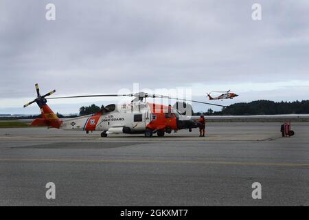 Coast Guard Air Station Sitka MH-60 Jayhawk Helikoptercrews, die Missionen auf der Air Station Sika durchführen, 21. Juli 2020. Eine Crew der Küstenwache bereitete sich nach Abschluss eines Medevacs auf die Landung vor, als sich eine Trainingscrew zum Start vorbereitete. Stockfoto