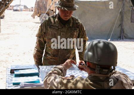 Pvt. Das Regimado, das dem Regimental Support Squadron, 11. Gepanzerte Kavallerie-Regiment, zugewiesen wurde, präsentiert seine gemeinsame Zugangskarte für den Eintritt in die Futterstelle, das Nationale Ausbildungszentrum und Fort Irwin, Kalifornien, 20. Juli 2021. Soldaten auf dem Futterplatz müssen an den Verfahren zur Mitarbeiterzahl teilnehmen, bevor sie die Einsatzlinie betreten. Stockfoto