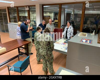 Das Museum Registrar Katherine Renfrew (ganz rechts) des Hampton Roads Naval Museum bietet eine kurze Führung durch den Anbau des Museums, der sich im Gebäude H-9 an Bord der Naval Station Norfolk befindet, für Besucher von Seeleuten und Freiwilligen des Museums. Stockfoto