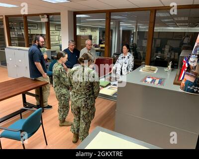 Das Museum Registrar Katherine Renfrew (ganz rechts) des Hampton Roads Naval Museum bietet Besuchern und Freiwilligen des Museums eine kurze Tour durch den Anbau des Museums im Gebäude H-9 an Bord der Naval Station Norfolk. Stockfoto