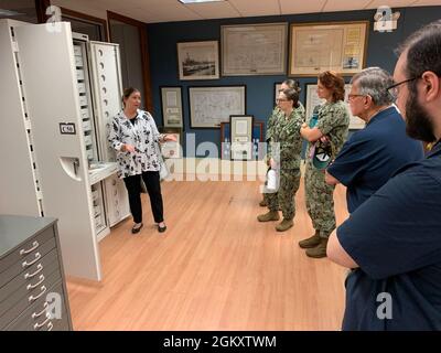 Das Museum Registrar Katherine Renfrew (links) des Hampton Roads Naval Museum bietet eine kurze Führung durch den Anbau des Museums, der sich im Gebäude H-9 an Bord der Naval Station Norfolk befindet, für Besucher von Seeleuten und Freiwilligen des Museums. Stockfoto