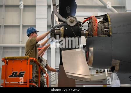 US Air Force Staff Sgt. Johnathon Brace (vorne) und Airman 1st Class Derek Mockalis, 103rd Maintenance Squadron Aerospace Propulsion Technician, installieren einen Propeller auf einem C-130H Hercules Flugzeug während eines Propellerwechsels auf der Bradley Air National Guard Base in East Granby, Connecticut, 21. Juli 2021. Aerospace Propulsion Airmen testet, instand gesetzt und repariert alle Teile der Motoren und Propeller und spielt eine entscheidende Rolle bei der Aufrechterhaltung der Einsatzbereitschaft für die C-130H Hercules-Flotte des 103. Airlift Wings. Stockfoto