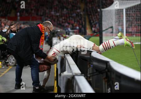 Liverpool, England, 15. September 2021. Theo Hernandez vom AC Mailand wird von einem Liverpool-Fan unterstützt, nachdem er während des UEFA Champions League-Spiels in Anfield, Liverpool, über die Werbetafeln gestolpert war. Bildnachweis sollte lauten: Nigel French / Sportimage Stockfoto