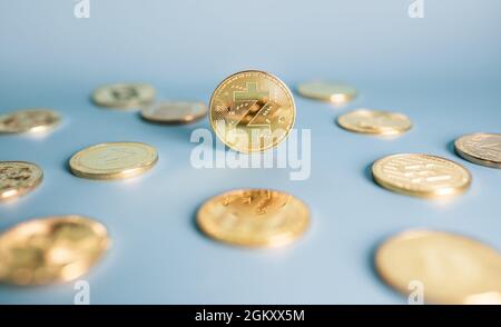 Zcash-Münze, die zentral zwischen einem Haufen Krypto-Münzen auf blauem Hintergrund platziert ist. Nahaufnahme, Weichfokus. Banner mit goldenem Zec-Zeichen. Stockfoto