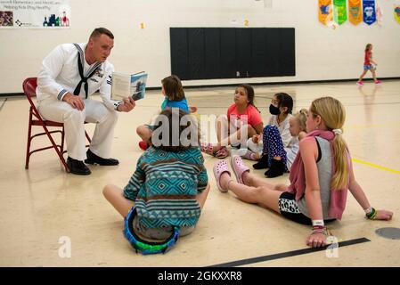 FARGO, N.D. (22. Juli 2021) Billy Dreher, US-Marinebuilder der 2. Klasse, der dem Operational Support Center Fargo der Marine zugewiesen wurde, liest Studenten der 3. Klasse bei einem Besuch der Roosevelt Elementary School in Fargo, N.D., Jul. 22. Die Veranstaltung ist Teil der Fargo Navy Week, die Segler aus verschiedenen Navy-Einheiten in den USA zusammenbringt, um gezielte Kontakte mit Mitgliedern der Gemeinde zu führen. Die Navy Weeks bestehen aus einer Reihe von Veranstaltungen, die vom Navy Office of Community Outreach koordiniert werden, um den Amerikanern die Möglichkeit zu geben, mehr über die Navy, ihre Menschen und ihre Bedeutung für die nationale Sicherheit und Pro zu erfahren Stockfoto