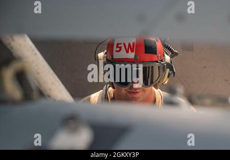 US Navy Airman Caleb Guess, Flugkommandeur, der dem Electronic Attack Squadron (VAQ) 138 ‘RAMPAGE!’ zugewiesen wurde Auf der Naval Air Station Whidbey Island, Washington, führt vor dem Start während der Red Flag 21-3 am Nellis Air Force Base, Nevada, 22. Juli 2021 Vorflugkontrollen durch. VAQ-138 ist ein taktisches Düsenflugzeug der US Navy, das sich auf die kinetische und nicht-kinetische Unterdrückung der feindlichen Luftverteidigung spezialisiert hat. Stockfoto