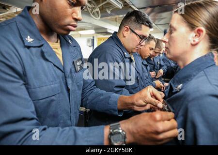 MITTELMEER (25. Juli 2021) Seeleute erhalten ihre als Surface Warfare Specialist eingetragenen Pins in einer Pinning-Zeremonie an Bord des Arleigh Burke-Klasse Lenkraketen-Zerstörers USS Ross (DDG 71), während sie am 25. Juli 2021 im Mittelmeer unterwegs waren. Ross, der im spanischen Rota stationiert ist, ist auf Patrouille im Einsatzgebiet der Sechsten Flotte der USA, um regionale Verbündete und Partner sowie nationale Sicherheitsinteressen der USA in Europa und Afrika zu unterstützen. Stockfoto