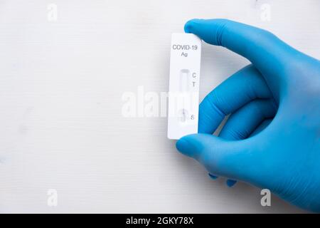 Covid-19 Antigentest zur schnellen Erkennung von Krankheiten bei Ärzten Hand in die Gummihandschuhe mit Kopieplatz. Coronavirus-Testkassette von Rapid Stockfoto