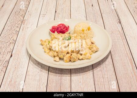 Mexikanischer Hühnereintopf mit Kürbisblüte, lila Zwiebeln und weißem Reis Stockfoto