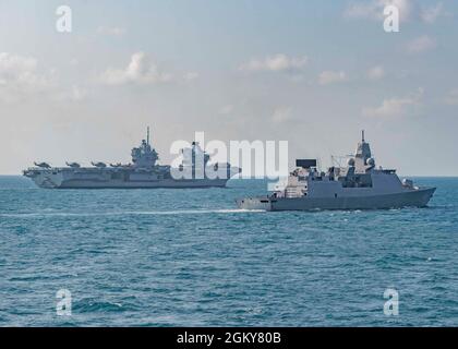 210726-N-UT641-0001 SÜDCHINESISCHES MEER (26. Juli 2021) der Flugzeugträger der Royal Navy HMS Queen Elizabeth (R08) und die Fregatte der Royal Netherlands Navy De Zeven Provinciën-Klasse HNLMS Evertsen (F805) nehmen während einer Fotoübung mit der Republic of Singapore Navy und der United Kingdom Carrier Strike Group eine Formation an Stockfoto