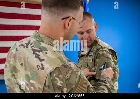 US Air Force Brig. General Robert Davis, Kommandant des 378th Air Expeditionary Wings, legt während Lockes Zeremonie zum Transfer der US-Weltraumwaffe auf der Prince Sultan Air Base, Königreich Saudi-Arabien, am 26. Juli 2021, einen neuen Patch für die Space Force für den US-Raumfahrtmajor Timothy Locke, Analyst für Pläne und Programme des 378th AEW, vor. Das Ereignis markierte den ersten Airman-to-Guardian-Transfer von PSAB und symbolisierte eine stetig wachsende Weltraumdomäne. Stockfoto