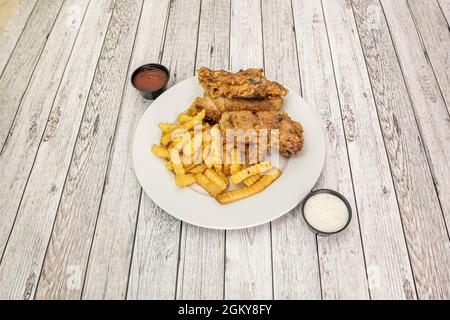 Knuspriger Kentucky Chicken Teller mit Pommes Frites und Saucen Stockfoto