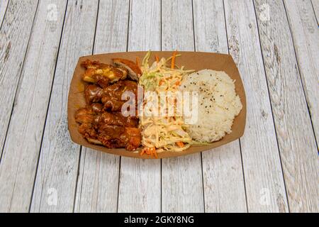 Asiatisches Rezept Karton Tablett mit knusprigem Hühnercurry mit Basmati-Reis und Salat und Karottensalat mit Saucen Stockfoto