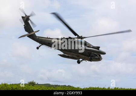 Ein UH-60 Black Hawk hebt am 27. Juli 2021 zur Unterstützung von Forager 21 von Northern Mariana Island, Tinian, nach Guam ab. Forager 21 wurde entwickelt, um die Fähigkeiten unterstützender Einheiten in allen Bereichen, Land, Luft, Meer, Weltraum und Cyber-Raum in der Indo-Pazifik-Region zu testen und zu verfeinern. Stockfoto