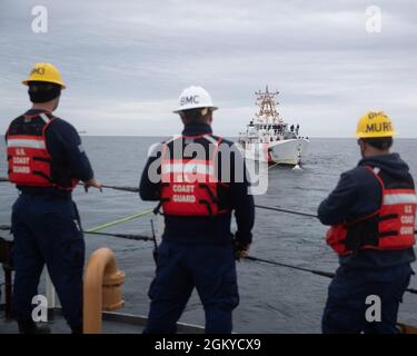 ATLANTISCHER OZEAN --(28. Juli 2021) Segler, die der USCGC Escanaba (WMEC 907) zugeteilt wurden, schauen während eines Abschleppvorgangs auf den 154-Fuß-Schnellwender der Sentinel-Klasse USCGC Richard Snyder (WPC 1127). USCGC Escanaba ist ein 270 Fuß großer, berühmter Mittelausdauerschneider mit einer Besatzung von rund 100 Mitarbeitern, die viele Missionen des Dienstes mit Schwerpunkt auf Strafverfolgung und Sicherheit durchführt. Stockfoto