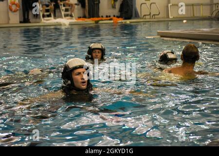 PENSACOLA, Florida (27. Juli 2021) Studenten des Aviation Survival Training Center (ASTC) Pensacola nehmen an einem Wasserüberlebenstraining Teil. ASTCs im ganzen Land bieten sichere und effektive Hochrisiko-Überlebens- und Humanleistungsschulungen unter dem Naval Survival Training Institute (NSTI), einer Abteilung des Navy Medicine Operational Training Command (NMOTC). Stockfoto