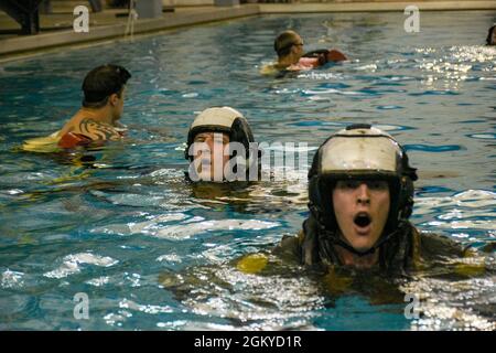 PENSACOLA, Florida (27. Juli 2021) Studenten des Aviation Survival Training Center (ASTC) Pensacola nehmen an einem Wasserüberlebenstraining Teil. ASTCs im ganzen Land bieten sichere und effektive Hochrisiko-Überlebens- und Humanleistungsschulungen unter dem Naval Survival Training Institute (NSTI), einer Abteilung des Navy Medicine Operational Training Command (NMOTC). Stockfoto