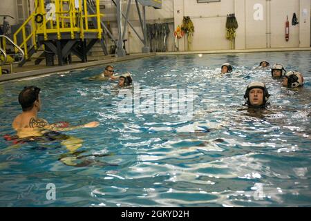 PENSACOLA, Florida (27. Juli 2021) Studenten des Aviation Survival Training Center (ASTC) Pensacola nehmen an einem Wasserüberlebenstraining Teil. ASTCs im ganzen Land bieten sichere und effektive Hochrisiko-Überlebens- und Humanleistungsschulungen unter dem Naval Survival Training Institute (NSTI), einer Abteilung des Navy Medicine Operational Training Command (NMOTC). Stockfoto