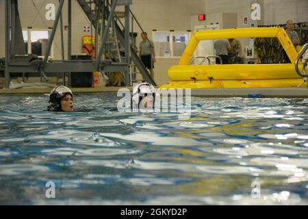 PENSACOLA, Florida (27. Juli 2021) Studenten des Aviation Survival Training Center (ASTC) Pensacola nehmen an einem Wasserüberlebenstraining Teil. ASTCs im ganzen Land bieten sichere und effektive Hochrisiko-Überlebens- und Humanleistungsschulungen unter dem Naval Survival Training Institute (NSTI), einer Abteilung des Navy Medicine Operational Training Command (NMOTC). Stockfoto