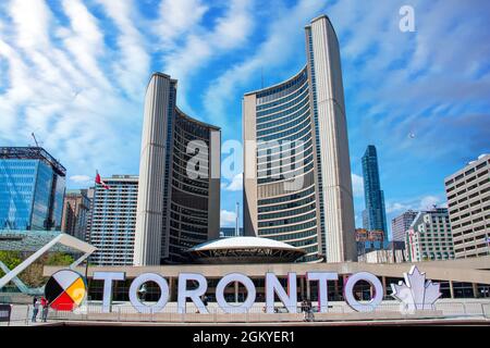 Toronto New City Hall auf dem Nathan Phillips Square, Kanada. Das Bild enthält das 3D-Zeichen mit einem First Nations-Zeichen links und das Maple Leaf Th Stockfoto