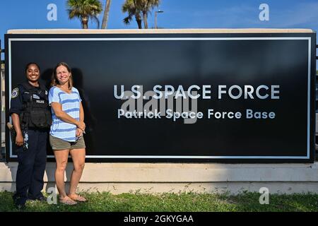 Christy Kalicharan (links), Polizeibeamter der 45. Sicherheitskräfte-Staffel und Gretta Lowry (rechts), Cocoa Beach, Florida, Bewohner posieren für ein Gruppenfoto auf der Patrick Space Force Base, Florida, 28. Juli 2021. Kalicharan lieferte Lowry lebensrettende Hilfe, nachdem sie beim Surfen von einem Hai gebissen wurde. Stockfoto