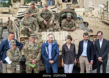 Robert S. Gilchrist, US-Botschafter in Litauen (Mitte-links), Margiris Abukevičius, Vizeminister der nationalen Verteidigung (Mitte-rechts), Und Audra Plepytė, litauischer Botschafter in den USA (zweiter von ganz rechts), posiert für ein Foto mit Mitarbeitern und Soldaten des 3. Bataillons, des 66. Panzertregiments vor ihrem Kampffahrzeug M2A3 bradley auf dem Trainingsgelände in Pabrade, Juli 29. Dieser Besuch ist Teil einer Tour durch das Pabrade-Trainingsgebiet, das Litauen mit nationalen Ressourcen erweitert und dabei seine Größe etwa verdoppelt und gleichzeitig die Infrastruktur und Kapazitäten verbessert hat. Diese Reichweiten-Erweiterungen Stockfoto