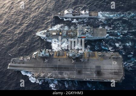 Eine US Marine mit Marine Fighter Attack Squadron 211 startet eine F-35B von HMS Queen Elizabeth, während sie am 29. Juli 2021 im Südchinesischen Meer eine doppelte Auffüllung mit RFA Tidespring und HNLMS Evertsen durchführt. VMFA-211 ist an die britische Carrier Strike Group 21 angeschlossen, eine von Großbritannien geführte internationale Streikgruppe, die unter anderem von der US-Marine Arleigh Burke Lenkrakenzerstörer USS the Sullivans (DDG 68) und der Royal Netherlands Navy HNLMS Evertsen unterstützt wird. Eine freie und offene Region im Indo-Pazifik-Raum, die friedlich und stabil ist, ist von entscheidender Bedeutung, um mehr Wohlstand für die Region und die zu gewährleisten Stockfoto