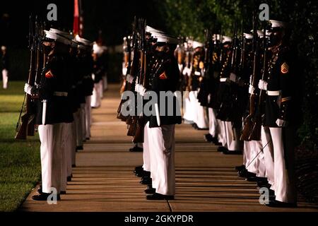 Marineinfanteristen mit Marinebarken Washington führen „gegenwärtige Waffen“ während der Freitagabend-Parade am MBW, 30. Juli 2021, aus. Ehrengast des Abends war die ehrenwerte Kathleen H. Hicks, 35. Stellvertretende Verteidigungsministerin, und Gastgeber war General David H. Berger, 38. Kommandant des Marine Corps. Stockfoto