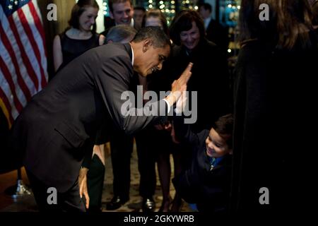 Präsident Barack Obama hat mit einem Jungen bei einer Spendenaktion für Bill Owens, den Kandidaten der Demokraten für den 23. Kongressbezirk von New York, im Mandarin Oriental Hotel in New York, NY, 20. Oktober 2009, ein Fünffelchen erreicht. (Offizielles Foto des Weißen Hauses von Pete Souza) Dieses offizielle Foto des Weißen Hauses wird nur zur Veröffentlichung durch Nachrichtenorganisationen und/oder zum persönlichen Druck durch die Betreffzeile(en) des Fotos zur Verfügung gestellt. Das Foto darf in keiner Weise manipuliert werden und darf nicht in kommerziellen oder politischen Materialien, Anzeigen, E-Mails, Produkten, Werbeaktionen, die in irgendwelchen verwendet werden Stockfoto