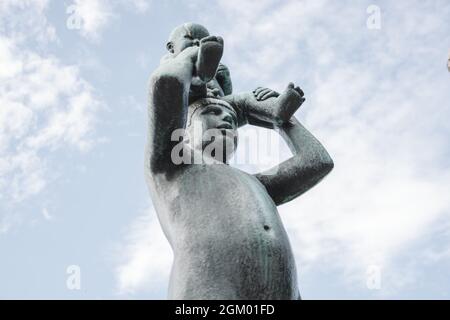 Aufnahme einer Bronzeskulptur einer Frau, die ein Baby in der Ausstellung von Gustav Vigeland in Oslo hält Stockfoto