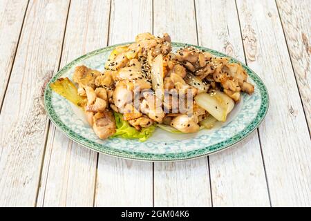 Teppanyaki-Hühnerrezept mit Gemüse, Knochen, gegrilltem Huhn in kleinen Stücken auf einem grünen Tablett Stockfoto