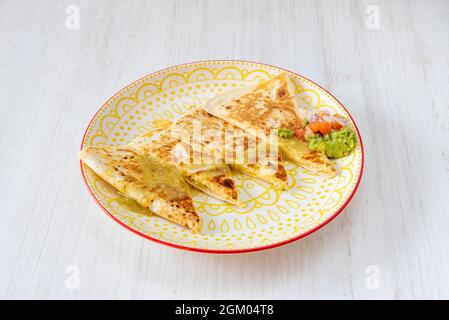 Synchronisierte Hähnchenquesadillas mit geschmolzenem Käse, Avocado-Sauce und Pico de gallo Stockfoto