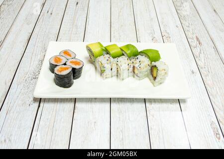 Thunfisch-Uramaki mit Lachs und Avocado, norwegischem Lachs Maki und Nori-Algen auf einem Sushi-Tablett Stockfoto