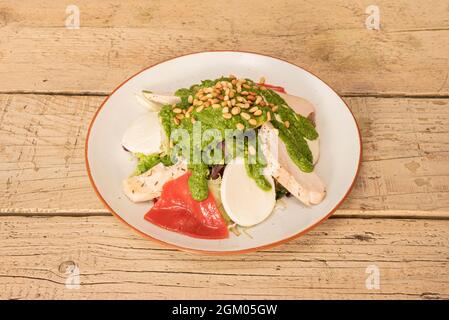 Hühnersalat mit Piquillo-Paprika, Burgos-Käse, Pinienkernen und Pesto-Sauce Stockfoto