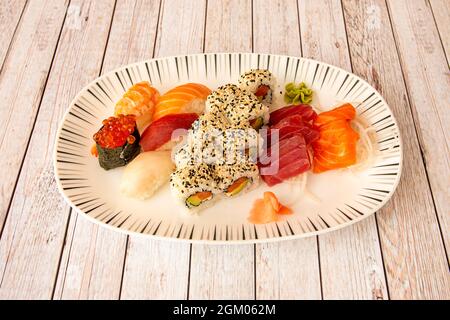 Schnell sortiertes Sushi-Tablett mit Garnelen-Nigiri und Butterfisch, Uramaki califorinia-Rolle gefüllt mit frischem Käse, norwegischem Lachs und Nori-Algen. Gunka Stockfoto