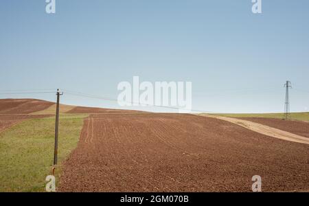 Bodenreihen vor der Bepflanzung am Hang. Furchen Reihen Muster in einem gepflügten Feld für die Pflanzung von Pflanzen im Sommer im iran vorbereitet. Stockfoto