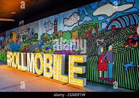 Ein beleuchtetes Schild für Roll Mobile, die monatliche Skate Night der Stadt, wird auf der Dauphin Street in der Nähe des Bienville Square, 10. September 2021, in Mobile, Alabama, aufgestellt. Stockfoto