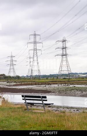 Bank mit Blick auf Strommasten und den Fluss Test in Eling Waterfront, Totton, Southampton, Hampshire, England, VEREINIGTES KÖNIGREICH Stockfoto