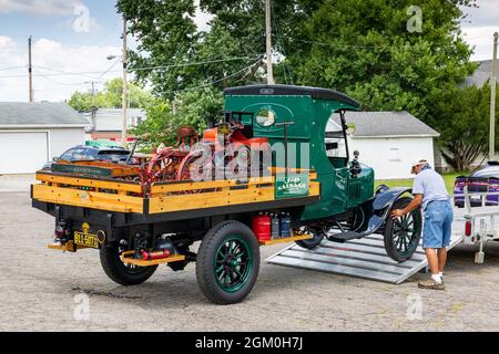 Ein Mann lädt seinen grünen 1924 Ford Model-T C Taxi Pickup LKW, beladen mit anderen Antiquitäten, auf einen Anhänger nach einer Auto-Show in Fort Wayne, Indiana, USA. Stockfoto