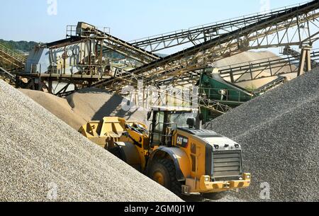 09. September 2021, Sachsen, Löbnitz: Ein Radlader transportiert Kies zu den Seitenablagen der Verarbeitungsanlage der Kieswerk Löbnitz GmbH & Co. Kg transportiert Kies zu den Seitenablagen der Verarbeitungsanlagen. Die zur Diringer & Scheidel-Gruppe (D&S) Mannheim gehörende Kiesanlage extrahiert und verarbeitet jährlich rund 750,000 Tonnen Kies, Kiesmischungen und Sand in verschiedenen Korngrößen. Foto: Waltraud Grubitzsch/dpa-Zentralbild/ZB Stockfoto