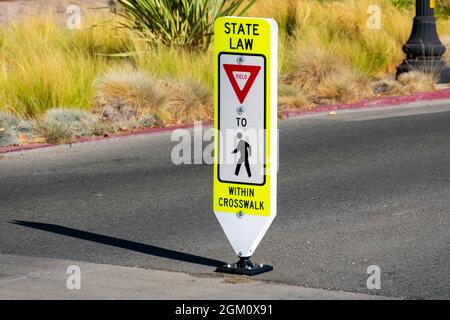 Staatliche Gesetz Rendite für Fußgänger innerhalb Crosswalk reboundable Straßenschild. Stockfoto
